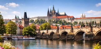 Vista panoramica di Praga con il Ponte Carlo e il Castello illuminati dal sole, meta ideale per un weekend in Europa
