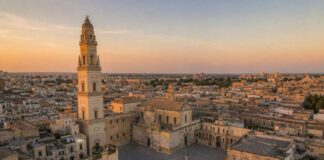 Weekend a Lecce: 5 cose da fare, 5 cose da mangiare e 5 cose da vedere Illustrazione realistica generata con intelligenza artificiale della Piazza del Duomo di Lecce al tramonto, con la Cattedrale e il campanile in stile barocco.